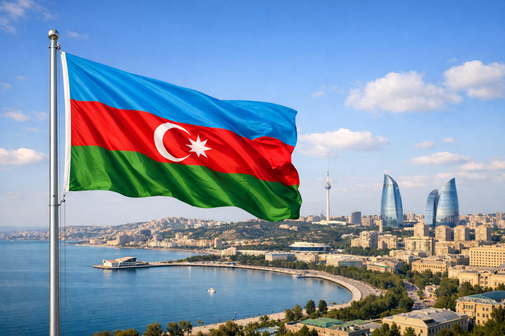Nationalflagge von Aserbaidschan mit blauem, rotem und grünem Streifen sowie weißem Halbmond und achtzackigem Stern, links am Fahnenmast wehend, vor der Küsten‑ und Stadtkulisse von Baku mit Kaspischem Meer, moderner Skyline und den Flame Towers im 16:9‑Format