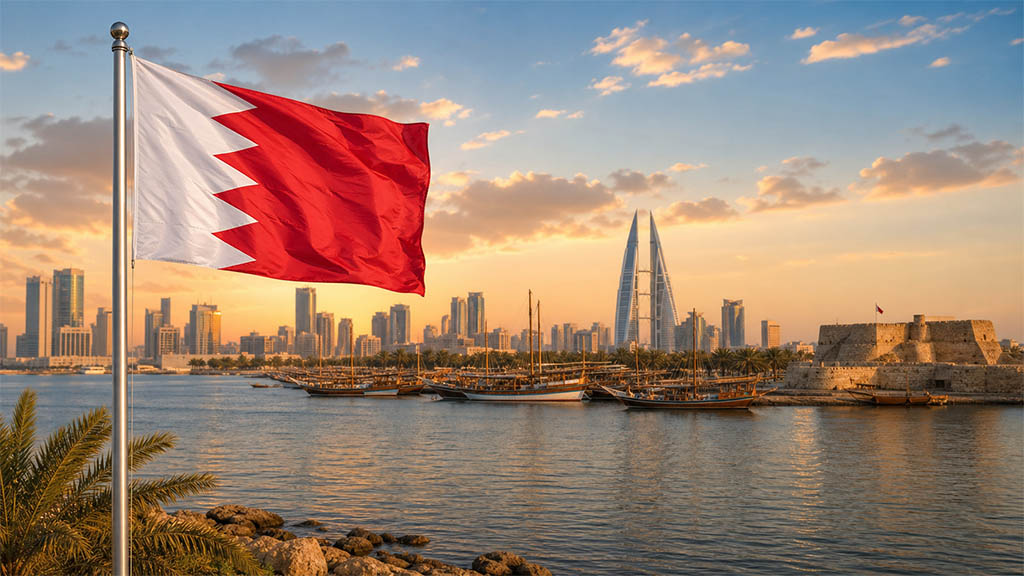 Flagge Bahrains vor traditionellen Dhau-Booten, der Skyline von Manama mit dem Bahrain World Trade Center und der Qal'at al-Bahrain in warmer Abendstimmung.