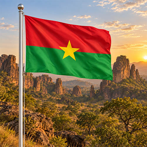 Burkina Faso Flagge am silbernen Fahnenmast vor den markanten Sindou Peaks und der westafrikanischen Savannenlandschaft im warmen goldenen Abendlicht.