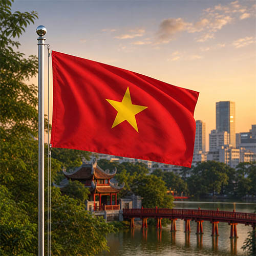 Vietnam Flagge - Bedeutung, Farben, Symbolik & Herkunft Flagge Vietnams vor dem Ngọc-Sơn-Tempel, der roten Húc-Brücke und der Skyline von Hanoi in warmer Abendstimmung.